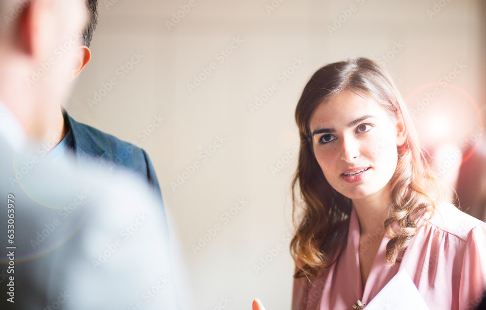 Young businesswoman talking to colleagues in office Young businesswoman talking to colleagues in office