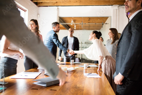 Businesspeople shaking hands during meeting in conference room