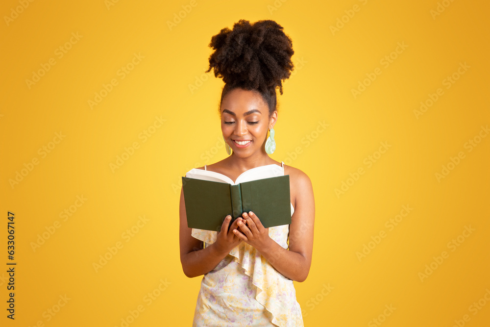 Glad smart pretty millennial black lady reading book alone, enjoy free time, planning day Glad smart pretty millennial black lady reading book alone, enjoy free time, planning day