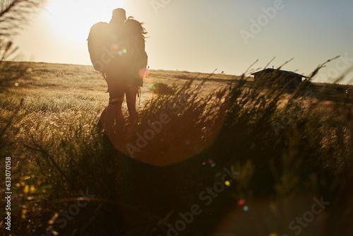 Silhouette of couple in field at sunset photo