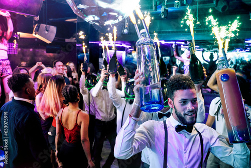 Bartenders with sparklers at nightclub © Image Source