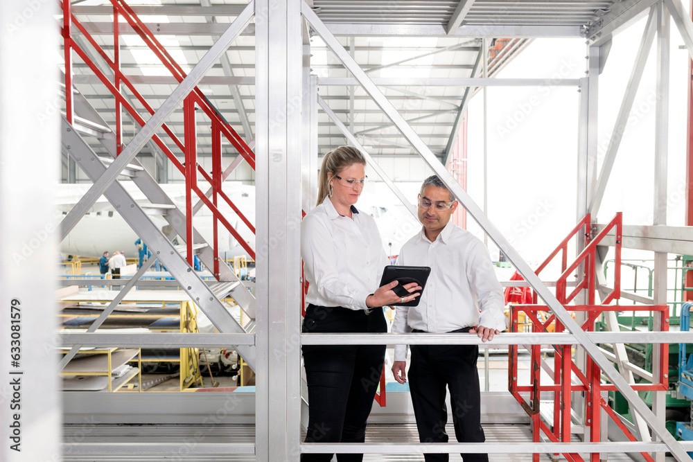 Businesspeople using digital tablet on staircase Businesspeople using digital tablet on staircase
