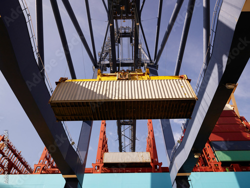 Crane unloading cargo container from ship