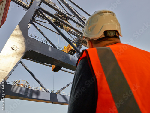 Low angle view of dock worker beneath crane at Port of Felixstowe, England photo