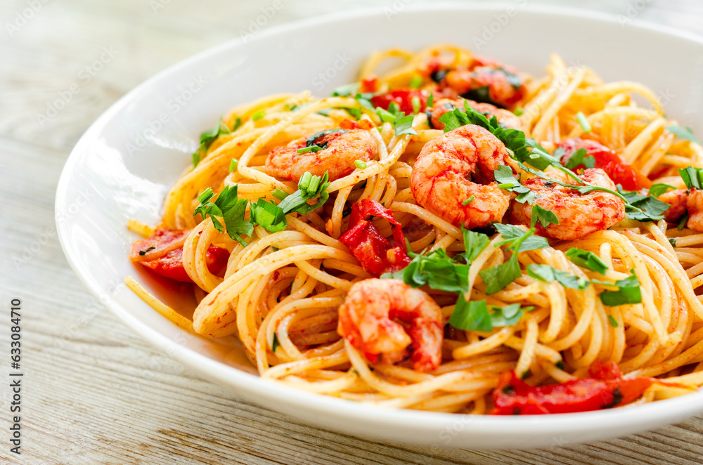 Piatto di deliziosi spaghetti con pomodoro, prezzemolo e gamberetti, cibo italiano 