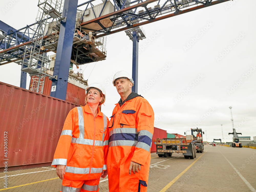 train dock worders talking while cargo is loaded to lorry waiting by ...