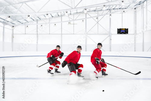 Ice hockey players skating in red uniforms photo