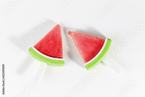 Two red cool refreshing watermelon ice lollies on white background