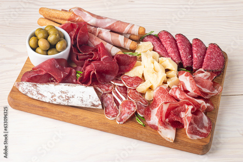 Charcuterie board. Antipasti appetizers of meat and cheese platter with salami, prosciutto crudo or jamon and olives