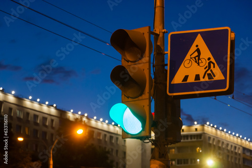 Green signal light on the background of the evening city.