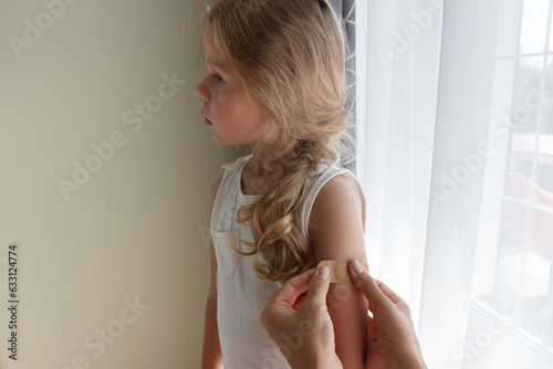 Arm with a plaster on the skin. Concept of vaccination and immunization, soft focus background © lisssbetha