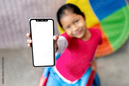 Niña latina emocionada sosteniendo una pantalla de celular en la mano presentando la pantalla vacía del teléfono. Maqueta de pantalla de teléfono inteligente. 