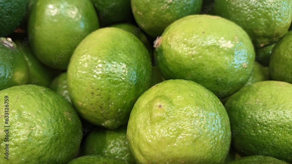 Green lemons on the counter in the market in a drawer Green lemons on the counter in the market in a drawer