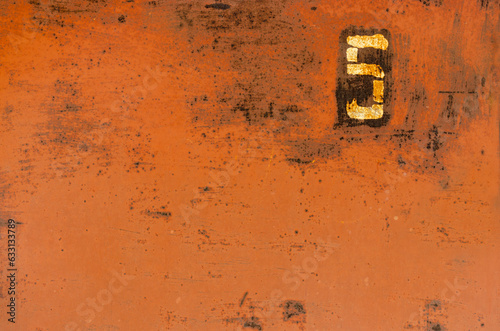 Old metal painted texture. Red painted background . Painted surface with rust. The plate with the number 5 on a rusty metal wall. Old uneven iron surface. Perfect for grunge design.