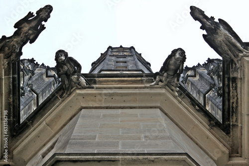 architectural view of a tower that contains sculptures of birds on the steps