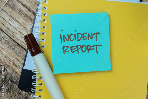 Fotografie Concept of Incident Report write on sticky notes isolated on Wooden Table