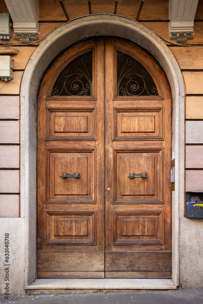 Rounded double dark old European wood doors of an apartment, building or home in Rome Italy Rounded double dark old European wood doors of an apartment, building or home in Rome Italy
