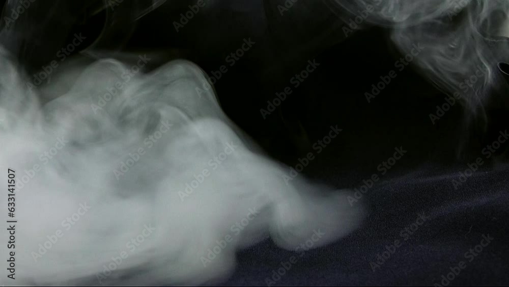 Smoke bursts into the black background in the video
Smoke bursts into the black background in the video