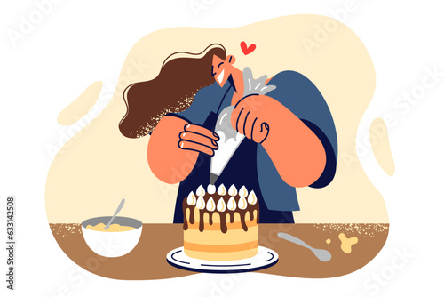 Woman confectioner decorates cake with butter cream making dessert for birthday party celebration