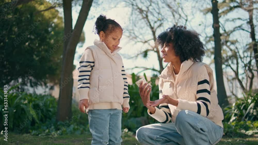 Mother daughter relaxing green park. African american woman talking little girl Mother daughter relaxing green park. African american woman talking little girl