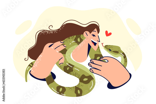 Woman with snake around neck smiles and looks at green python, rejoicing at presence of beloved pet