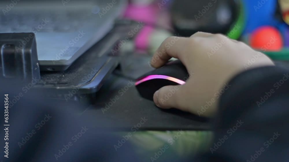 Mano de niño sosteniendo un mouse de computadora