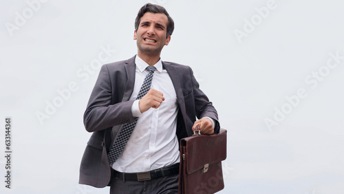 Studio shot of a mature businessman running with a briefcase iso photo