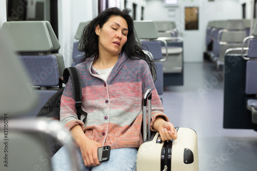 Tired asian woman fell asleep in the subway car photo
