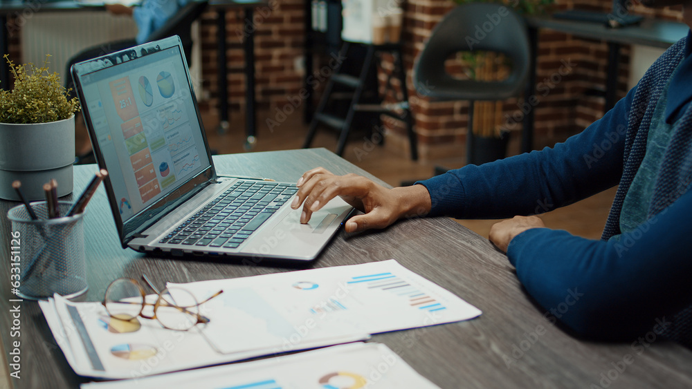 Young businessman working with laptop and reviewing company analytics, trying to increase profit with annual statistics. Employee in startup office planning corporate development, data reports. Young businessman working with laptop and reviewing company analytics, trying to increase profit with annual statistics. Employee in startup office planning corporate development, data reports.