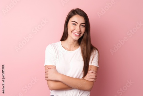 Young beautiful girl in a white T-shirt on a pink background
