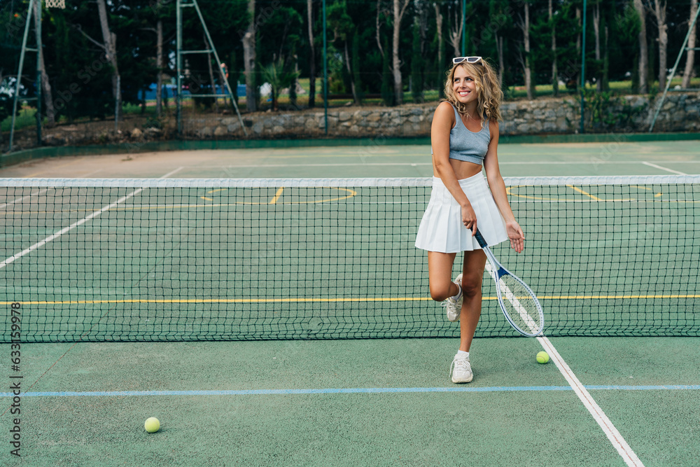 Beautiful blonde girl posing on the tennis court with a racket in her hands. fashion beauty makeup style