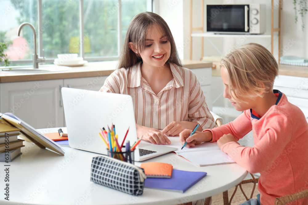 Little boy doing homework with his mother in kitchen Little boy doing homework with his mother in kitchen