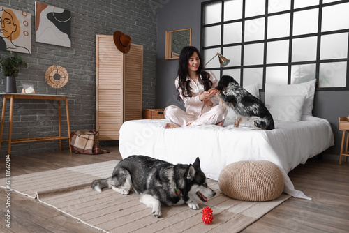 Canvas Print Young woman with cute dogs in bedroom