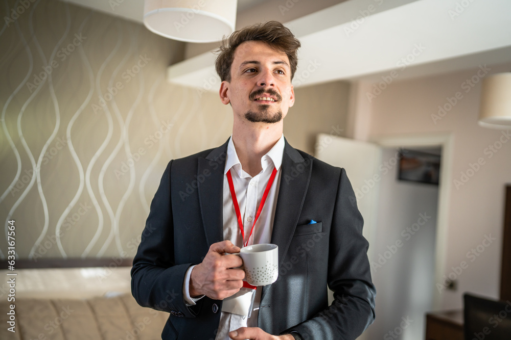© Miljan Živković - One man caucasian male adult stand with cup of coffee in hotel room © Miljan Živković - One man caucasian male adult stand with cup of coffee in hotel room