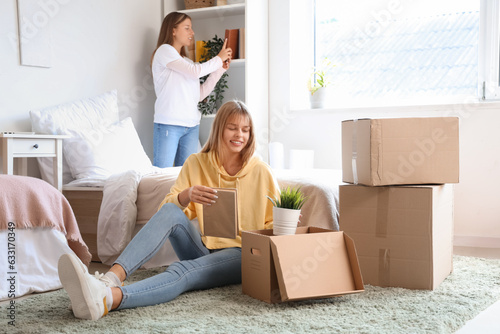 Female student unpacking things in dorm room on moving day