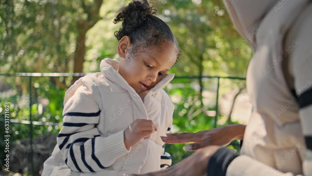 African american girl playing with mom hands sitting bench green park close up. African american girl playing with mom hands sitting bench green park close up.