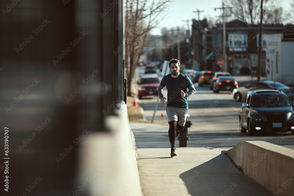Young man jogging and exercising on a sidewalk on a bridge in the city