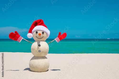 Snowman. Snowman with red Santa Claus hat and mittens. Merry Christmas and Happy New Year. Sandy Snowman on the beach. Smiling snowman. Miami Beach Florida. Celebration Winter Holidays. Xmas postcards
