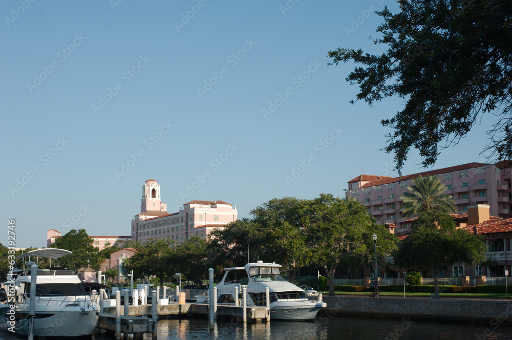 Vinoy Yacht Basin Marina in St. Petersburg, Florida and Park on an early morning sunny day. Lamp post near sidewalk, boats and building in background. Green grass.