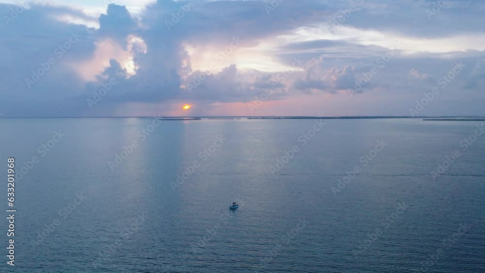 Boat drifting slowly over open ocean in the Florida Keys during gorgeous Sunset