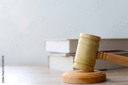 Side view of judge gavel on wooden table near law books, justice concept. 