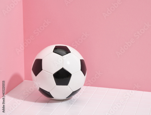 A soccer ball lies on a white tile. Copy space for text. Workout equipment.