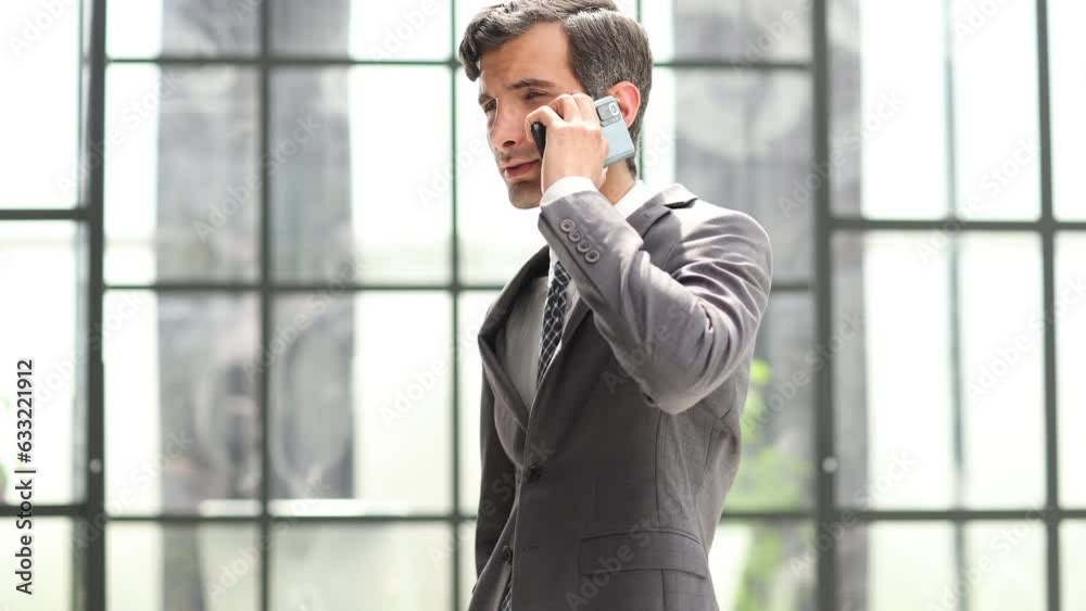 Young business man using mobile phone in the office hallway Young business man using mobile phone in the office hallway