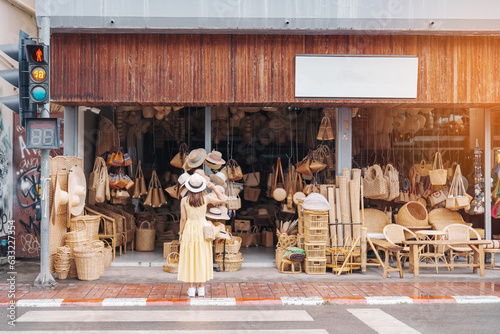 Young asian woman traveler in dress with hat traveling to wicker shop on Chang Moi Kao Road, Tourist visit at the old city in Chang Mai, Thailand. Asia Travel, Vacation and summer holiday concept