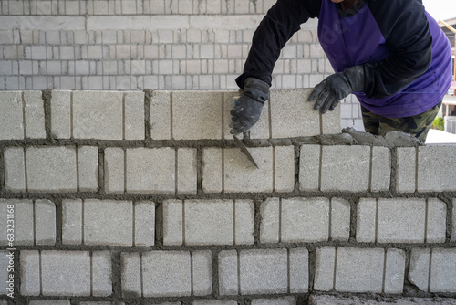 a worker erects a wall of aerated concrete blocks. photo