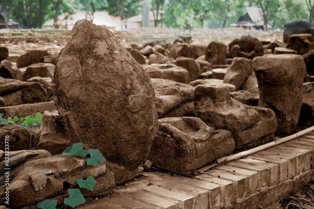 Fototapeta premium The broken remains of an ancient 20th-century Buddha statue in sepia tone