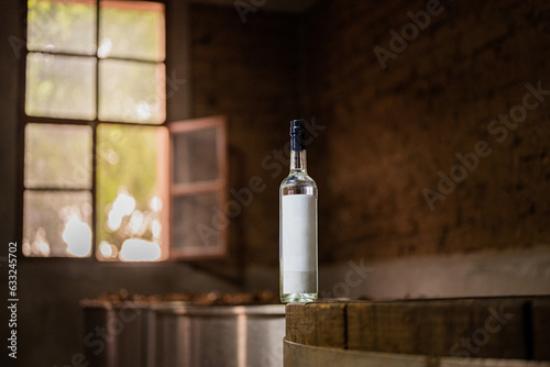 Botella de destilado en barricas de madera photo