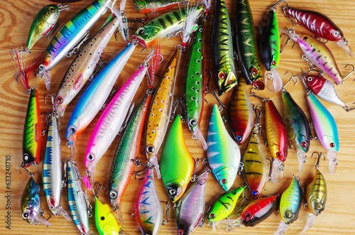 Fishing spinning lures on a wooden texture.