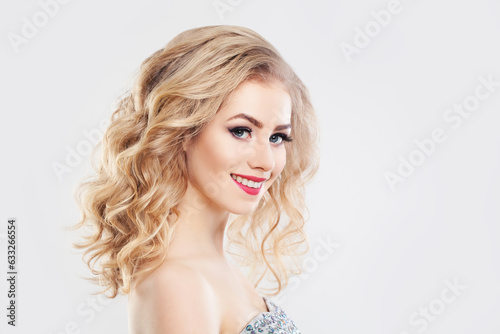 Happy smiling blonde woman with long healthy curly hair, clear skin and cheerful smile. Facial treatment, haircare and cosmetology concept