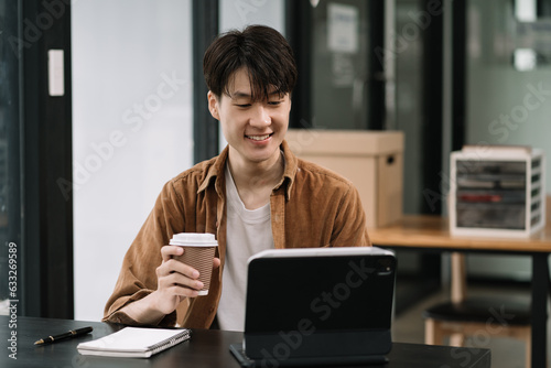 Male are using tablet to work at the desk in the morning.